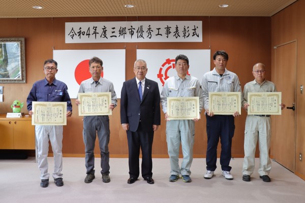 5名の男性が表彰状を持ち、木津市長とともに記念撮影をしている写真
