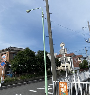 電柱の横にある薄い緑色の照明塔を写している写真