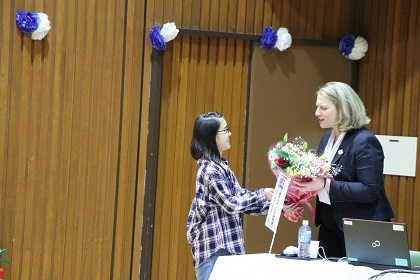 一人の小学生が駐日ギリシャ大使夫人に花束を手渡している写真