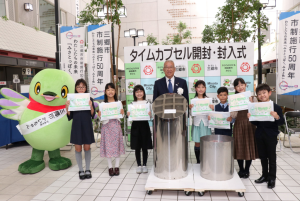 代表児童7人、かいちゃん、市長が横1列に並び一緒に記念撮影をしている写真