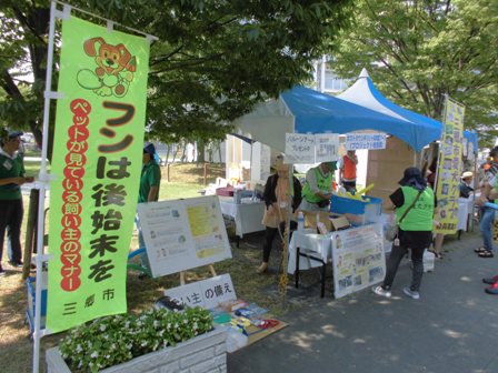 「フンは後始末を」と書かれたのぼり旗の奥にテントが設置され、飼い主の備えについての展示やバルーンアート等が置かれている三郷市愛犬クラブのブースの写真