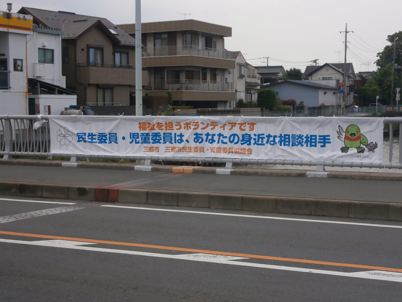 民生委員・児童委員活動PR用横断幕が三郷駅前大橋の欄干に結ばれている写真