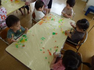 寒天で作ったおもちゃで遊ぶ1歳児数名の様子