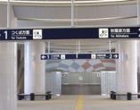 行先の看板が天井から下げられており、曲線のデザインが取り入れた駅構内の写真