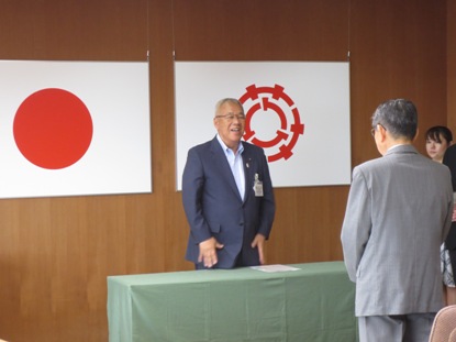 向かい合って立っている上野さんに市長が笑顔で挨拶を行っている様子の写真