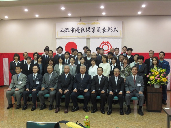 前列の椅子の中央に市長と7名の男性が座り、後列に受賞した方々が並んでいる記念写真