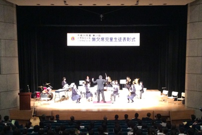 少人数の瑞穂中学校吹奏楽部のメンバーがステージ上で指揮に合わせながら演奏を行っている様子の写真