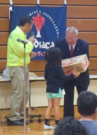 抽選会で当選した女の子が市長から段ボールに入った商品を受け取っている写真