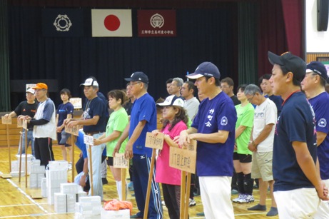 体育館にプラカードごとに並んで整列している参加者を左側から撮影した写真
