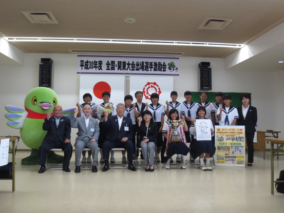 「平成30年度全国・関東大会出場選手激励会」の横断幕が設置されている部屋で、市長が北中学校女子ハンドボール部の関係者や生徒たち、かいちゃんと一緒に記念撮影をしている写真