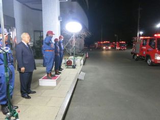 消防本部の建物の前を消防車が市内パトロールに出発していく様子を見守っている市長や敬礼している消防職員の方々の写真