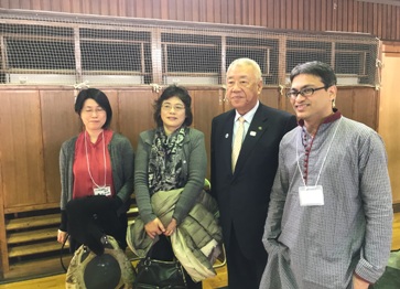 三郷市長と、首に名札をかけた国際交流フェスタの参加者のスーダン人の男女が記念撮影をしている写真