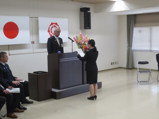 一名の女性職員が演台に立つ市長に宣誓をしている様子の写真