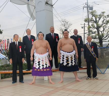 市長と胸章リボンをつけた4名の男性が横綱白鵬関と日馬富士関を囲んで立ち記念撮影をしている写真