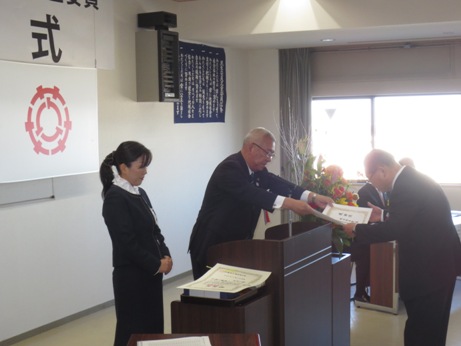 演台に立ち感謝状を贈呈する市長と、それを受け取る男性、市長の横に控える女性職員を写した写真