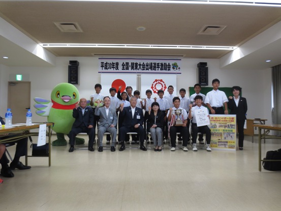 「平成30年度全国・関東大会出場選手激励会」の横断幕が設置されている部屋で、市長が北中学校男子ハンドボール部の関係者や生徒たち、かいちゃんと一緒に記念撮影をしている写真