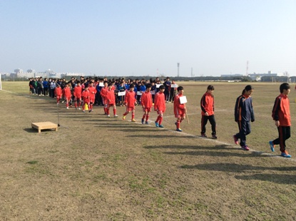 奥に集まった選手たちが白線に沿ってチームごとに入場行進を行っている様子の写真