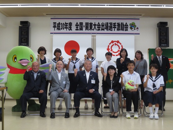 「平成30年度全国・関東大会出場選手激励会」の横断幕が設置されている部屋で、市長が早稲田中学校の関係者や生徒たちと一緒に記念撮影をしている写真