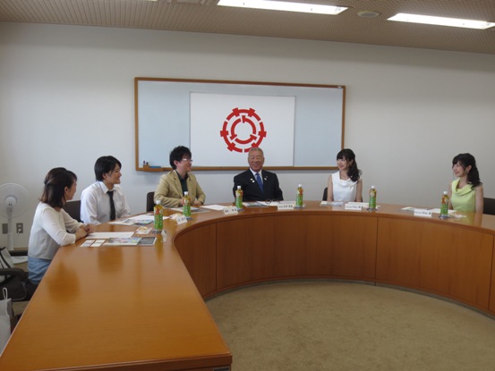 Uの字型の長机に5名の関係者が着席し、中央に座っている市長と歓談している様子の写真