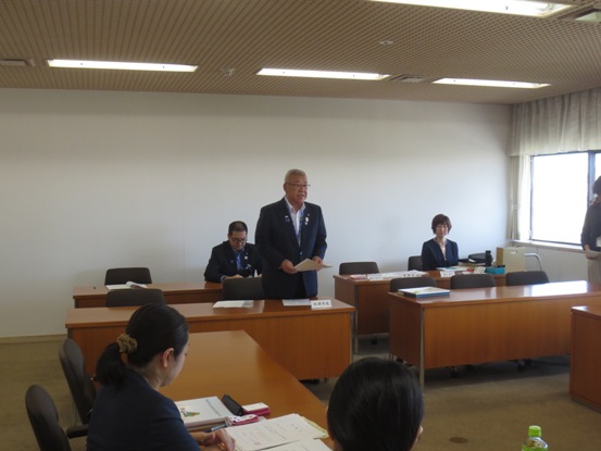 2列に並んだ席から立ち上がった市長が挨拶を行っている様子の写真