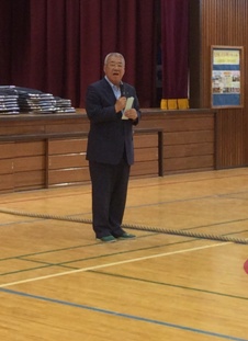 体育館のステージ下で挨拶を行っている市長の写真