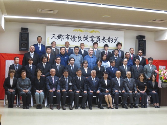 前列の椅子に市長を中央に受賞者が座り、4列目まで立ち並んでいる記念写真