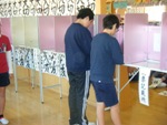 記載台を使って、投票用紙に記入している2名の男子児童の写真