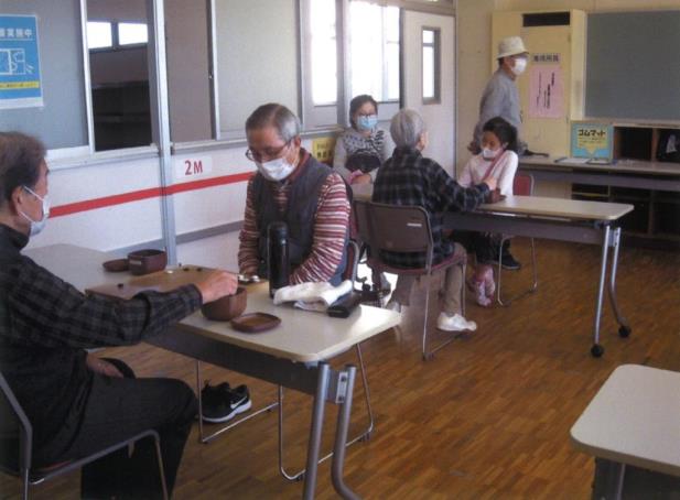 年配の男性同士が対局を行い、その奥で女の子と年配の方が対局を行っている様子の写真