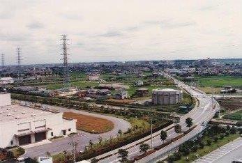 昭和63年(1988年)に上空から撮影された、前方に工場、後方に田んぼと建物が同じくらいの割合で位置している三郷駅方面の写真