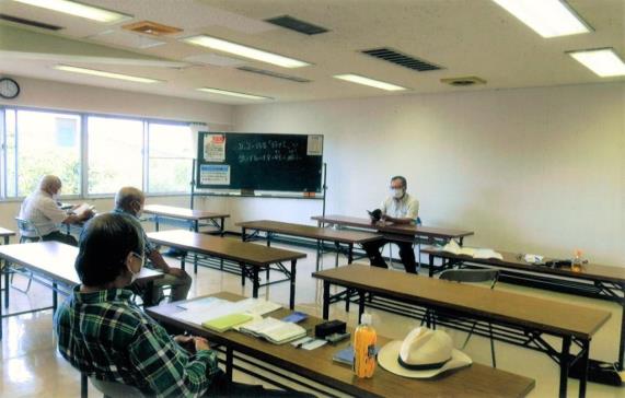 教室の前方に男性が座り手元の資料を見ながら口伝で吟じているのを、3名の男性が座って手元の資料を見ながら参加している練声会の様子の写真