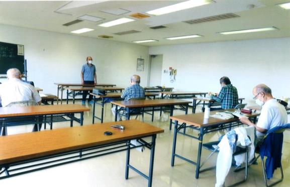 男性が前方に立ち学んだ詩吟を詠じており、他の参加者の方々は手元の資料を目で追っている写真