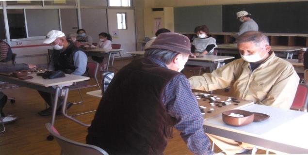 間隔をあけて机が置かれ、各席で4組ほどが対局を行っている様子の写真