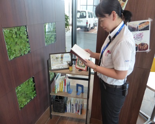 女性がふれあい文庫の本を手に取り読んでいる様子を横から写した写真