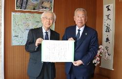木津市長と柳田邦男氏が応援メッセージを一緒に持って記念撮影をしている写真