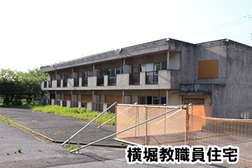 2階建てのコンクリートで作られた横堀教職員住宅の外観写真