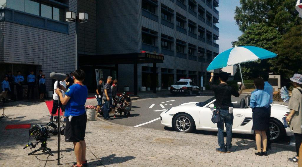 建物前の道路を使用して、多くの関係者たちが撮影をしている様子の写真