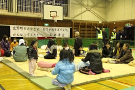 瑞沼市民センターの避難所に、ネットで仕切りを作り、マットを並べて被災者のみなさんを受け入れる様子の写真