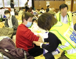 避難所の中で医師・保健師の方が被災者のみなさんの健康相談をする様子の写真