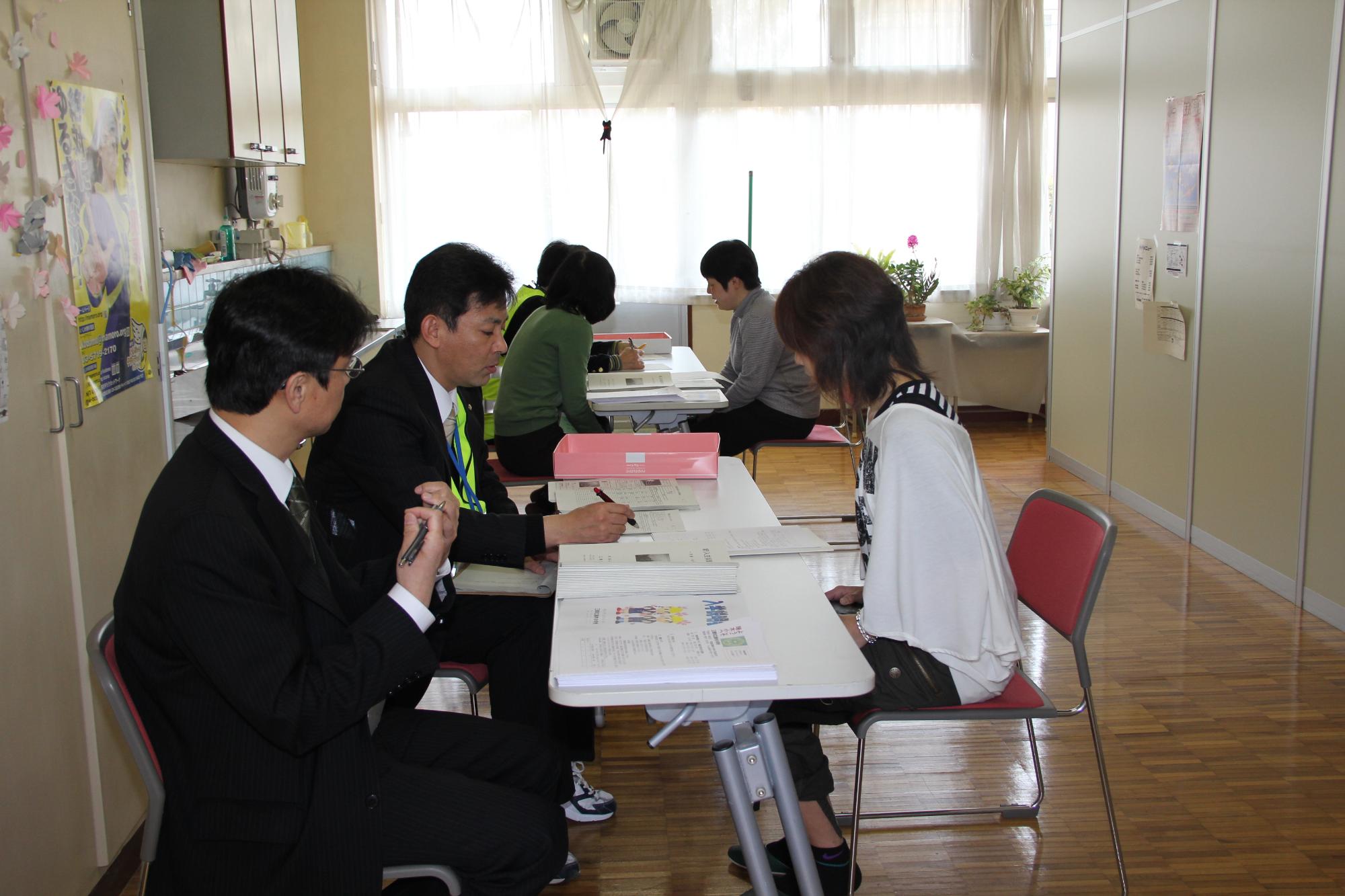 学生がスーツを着た男性2人と向い合せに座り就学相談をしている様子の写真