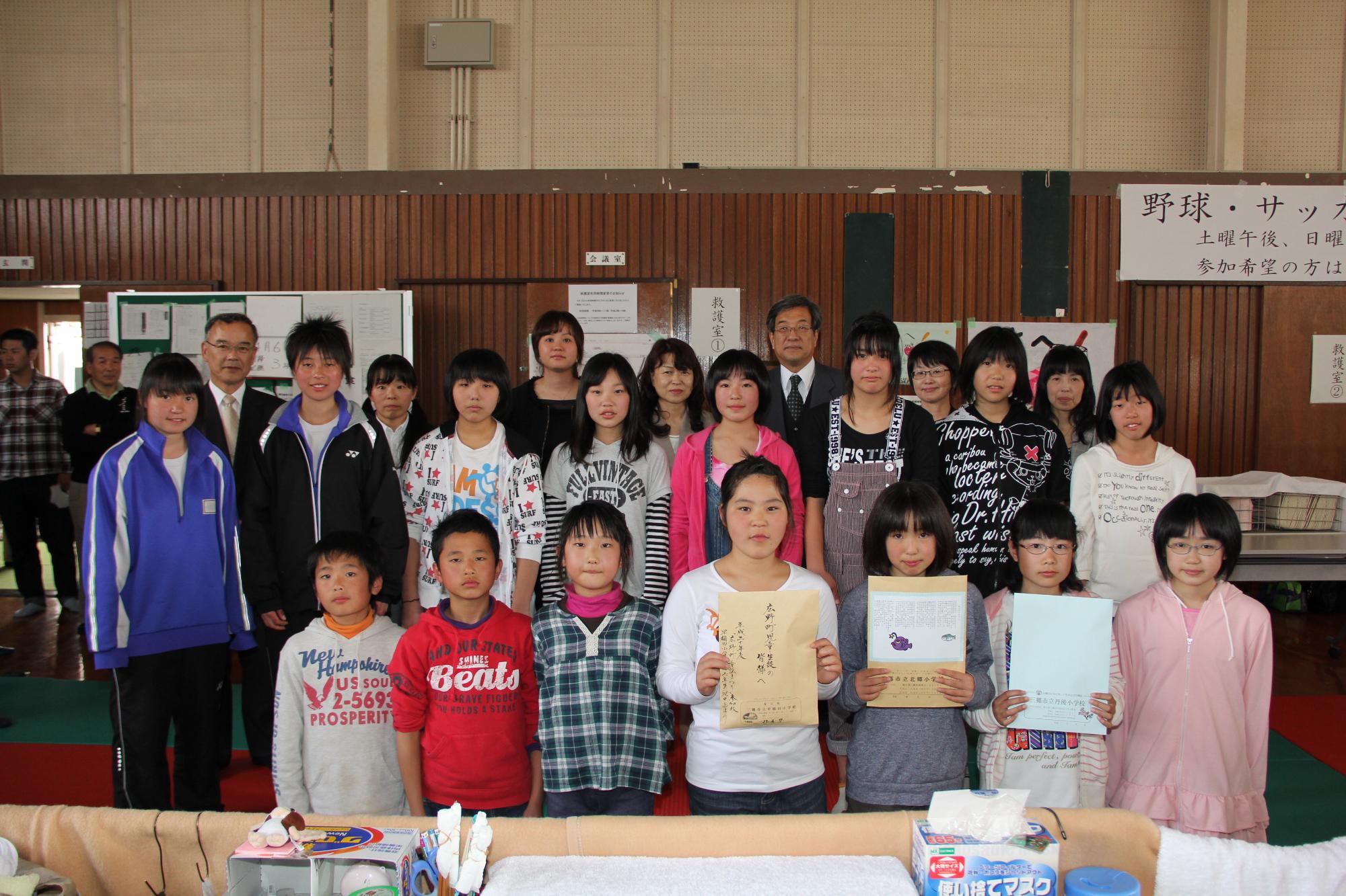 前に座った3名が受け取った手紙を持つ、三郷の子どもたちと広野の子どもたちの集合写真