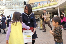 早稲田中学校生徒が募金活動をする募金箱に子供が募金している写真