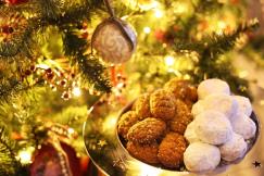 ライトアップされたツリーに照らされた茶色のメロマカロナと白色のクラビエデスのクリスマス菓子の写真