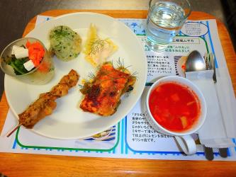 白い丸皿に5種類の料理が盛り付けられ、右側にスープカップに入った赤色のスープが添えられているギリシャ料理の写真