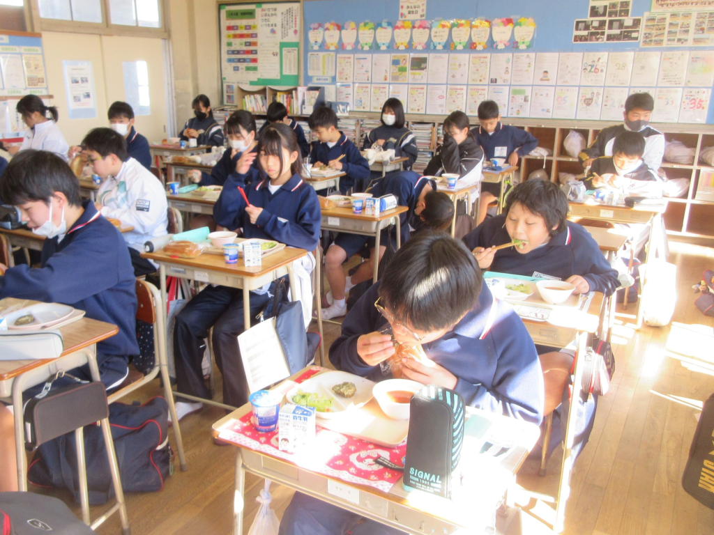 教室の自席に座って給食を食べている生徒たちの写真