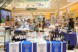 沢山の種類のワインの瓶が販売ブースに並んでいる写真