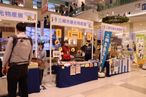 物産展に出店している左側の店舗の販売ブースの商品を見ているお客さんの後ろ姿の写真