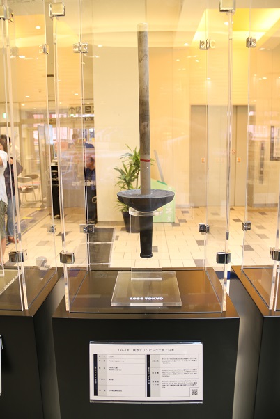 ガラスケースの中に展示されている東京五輪聖火トーチの写真