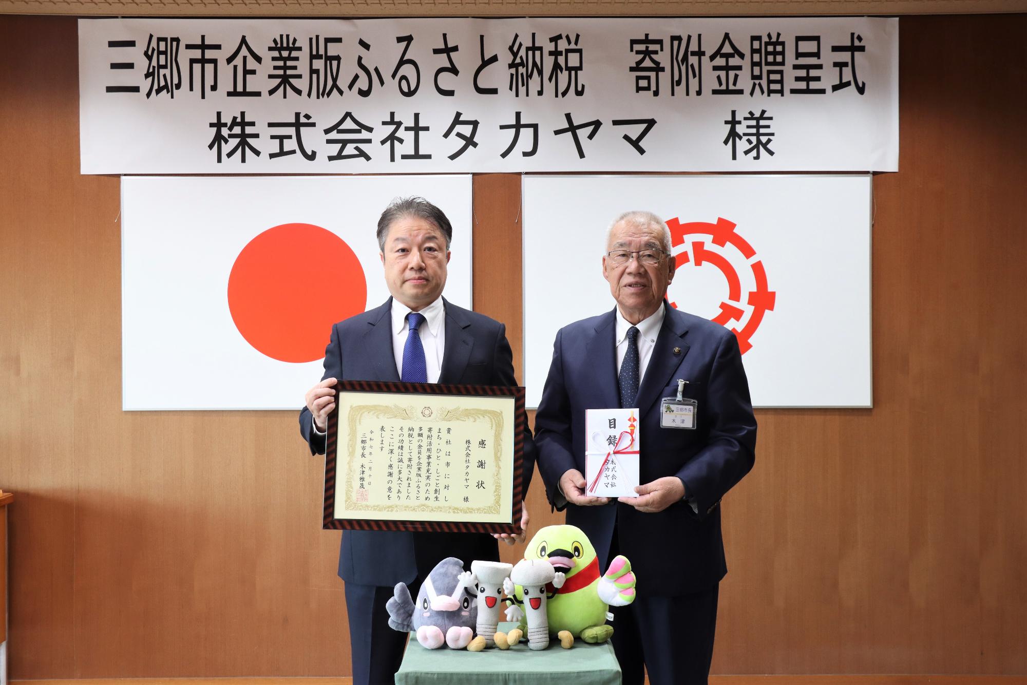 令和7年2月10日寄附金贈呈式（左から 高山伸和代表取締役、木津雅晟市長）
