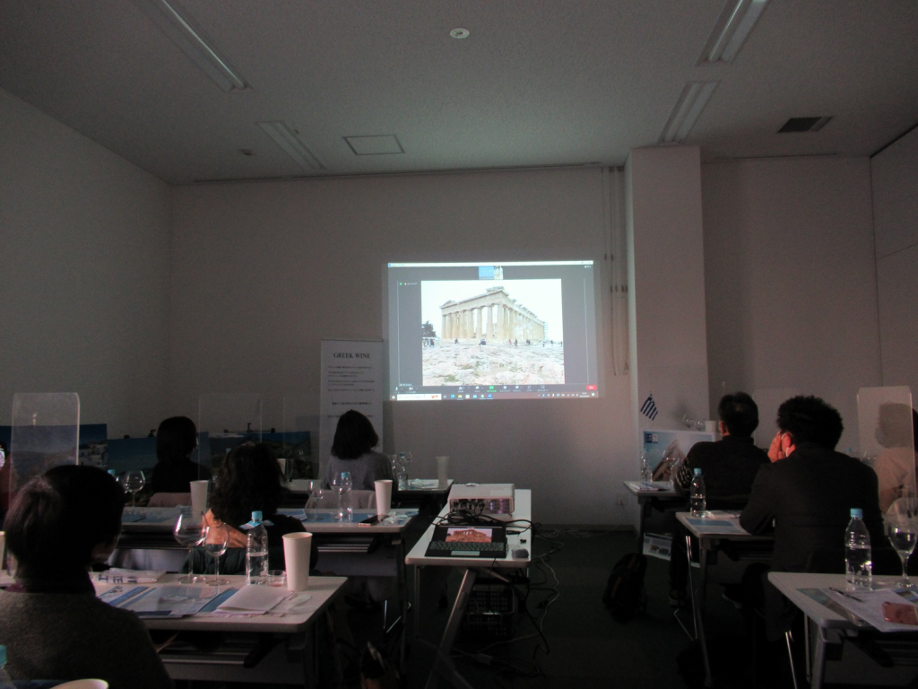 照明を落とした室内で壁に映し出された資料を参加者が熱心に見ている後ろ姿の写真