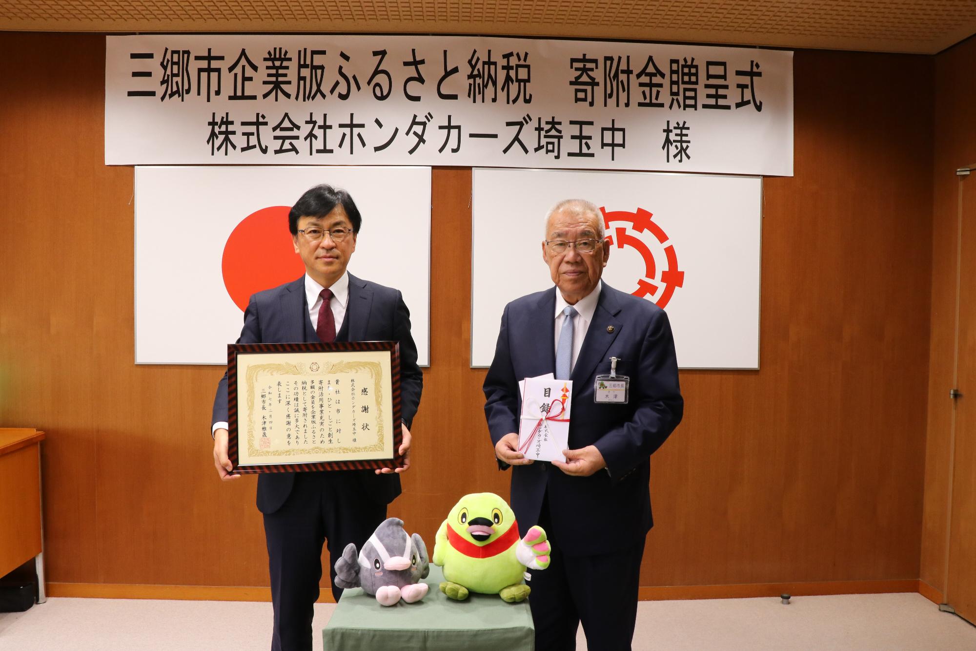 令和7年2月4日寄附金贈呈式（左から 石井敦代表取締役、木津雅晟市長）